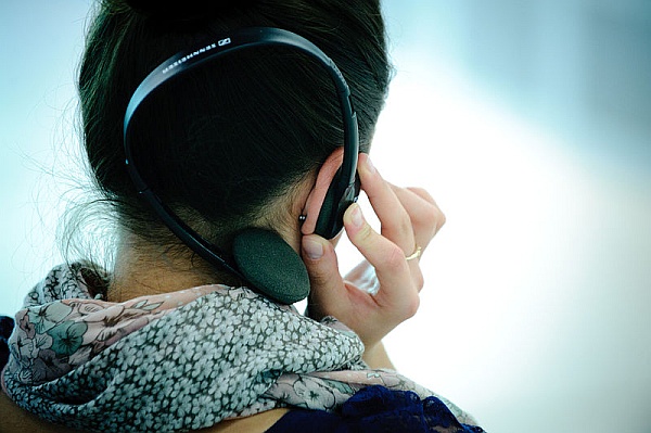 Woman listening with headphones (photo from Wikimedia Commons)
